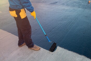 Roofer applying roof coating in Wheaton, IL